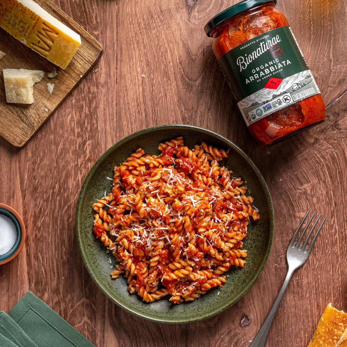 Pasta dish with Bionaturae organic arrabbiata sauce on a wooden table.